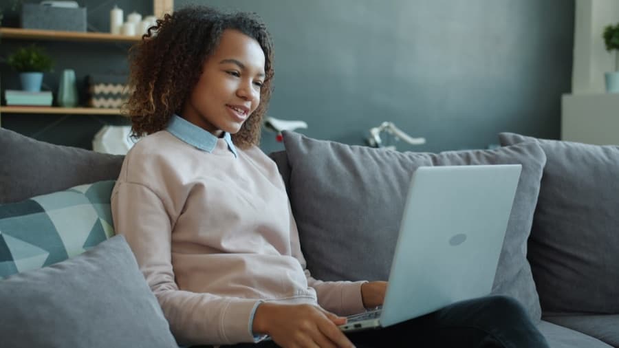 A person speaks with a clinician over a video call from their couch